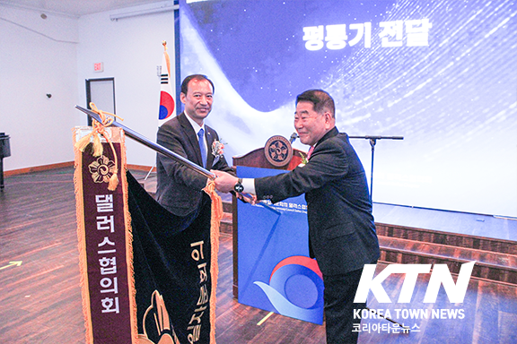 김원영회장이 오원성 전회장으로부터 평통기를 전달받고 있다.