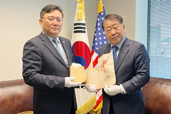 도광헌 주달라스영사출장소 소장에게 관련자료를 전달하고 있는 오원성 회장