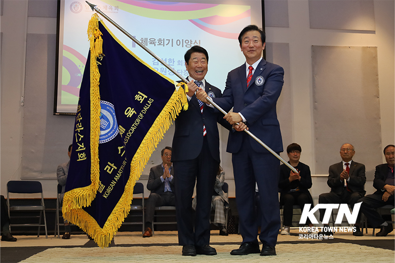 달라스체육회 오원성 단장(좌)에게 김성한 회장(우)이 달라스체육회기를 이양했다.