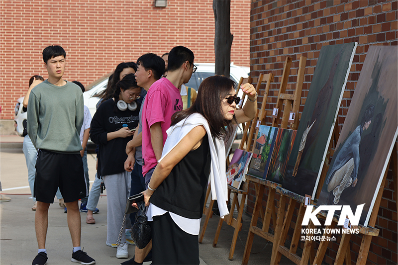 제16회 정기 미술 전시회를 관람하고 있다.