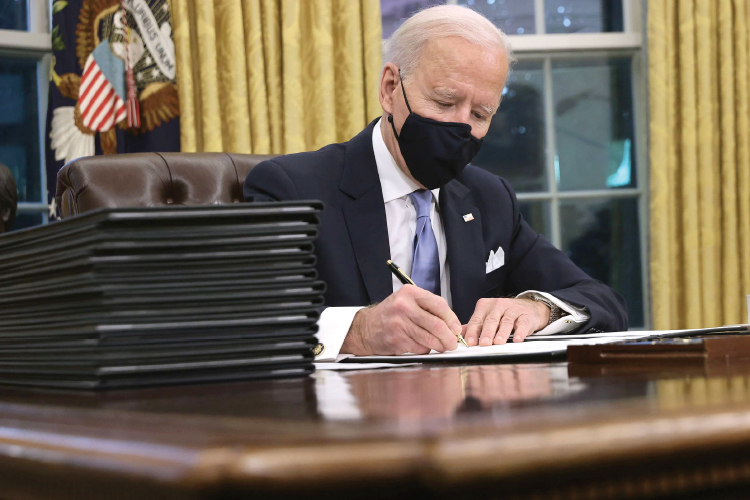 조 바이든 대통령이 20일 백악관 집무실 '결단의 책상(Resolute Desk)'에서 행정명령에 서명하고 있다. 